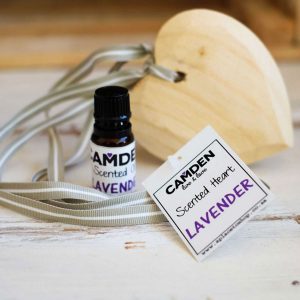 Scented heart and oil on wooden table
