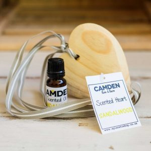 Scented heart and oil on wooden table